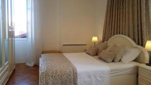 Cama blanca en habitación con ventana en Apartments by the sea Lovran, Opatija - 14180, en Lovran