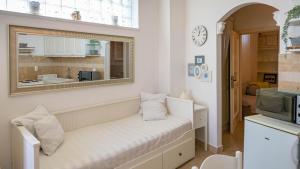een witte kamer met een bank en een raam bij Family friendly apartments with a swimming pool Lovran, Opatija - 14178 in Lovran