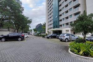 a parking lot with cars parked in front of a building at Apto Flat Midas na Via Olímpica Encantador in Rio de Janeiro