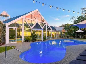 a swimming pool in front of a house at Broadwater Resort WA Tourism Awards 2022 Gold Winner in Busselton
