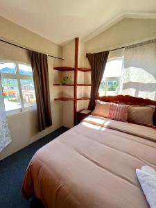 a hotel room with a large bed and two windows at La Casa del Profe 