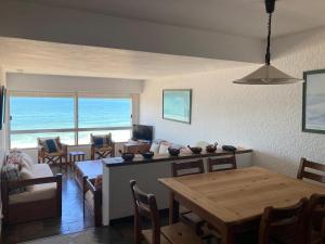 a living room with a table and a dining room at Departamento frente al mar in Punta del Este