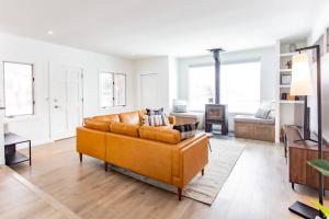 a living room with a couch and a television at Bridger Hawk - Mid-Century Classic (NEW) in Bozeman