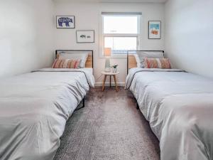 two beds are lined up in a room at Bridger Hawk - Mid-Century Classic (NEW) in Bozeman