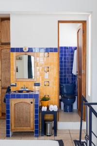 uma casa de banho com um lavatório azul e um WC. em Siento Oaxaca em Oaxaca de Juárez