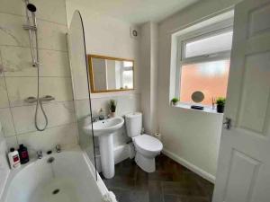 een badkamer met een toilet, een wastafel en een bad bij WiFi Free Secure Parking Stadium & City Centre in Sunderland