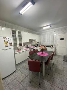 a kitchen with a table and a white refrigerator at Triplex 5 min do Jardim Botânico in Curitiba