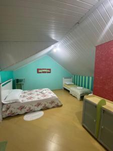 a room with two beds in a room with blue walls at Triplex 5 min do Jardim Botânico in Curitiba