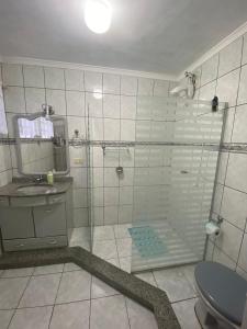 a bathroom with a shower and a sink and a toilet at Triplex 5 min do Jardim Botânico in Curitiba