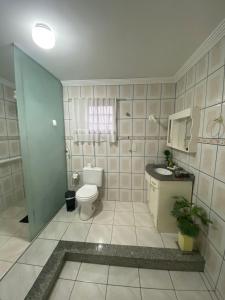 a bathroom with a toilet and a sink at Triplex 5 min do Jardim Botânico in Curitiba