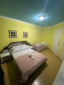 two beds in a room with yellow walls at Triplex 5 min do Jardim Botânico in Curitiba