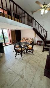 a living room with a table and chairs and a staircase at Cancún Suites Apartments - Hotel Zone in Cancún
