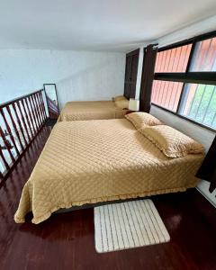 two beds in a room with two windows at Cancún Suites Apartments - Hotel Zone in Cancún