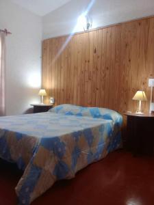 1 dormitorio con 1 cama y 2 mesas con lámparas en Cabaña Adonay Mina Clavero en Mina Clavero