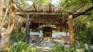 巴魯的住宿－Hotel Playa Scondida Baru，一个带椅子和桌子的木制凉亭