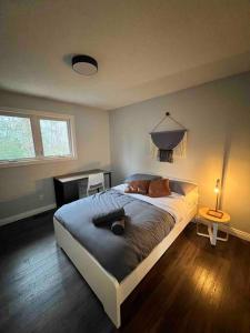 een slaapkamer met een groot bed en een lamp bij Spacious 4 Bedroom Forest Escape [Sunroom+Firepit] in Kawartha Lakes