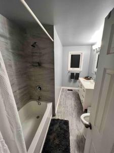 uma casa de banho branca com uma banheira e um lavatório em Spacious 4 Bedroom Forest Escape [Sunroom+Firepit] em Kawartha Lakes