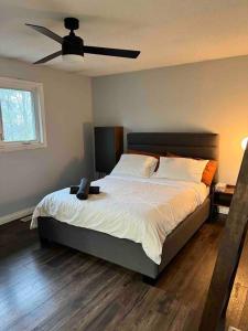 um quarto com uma cama e uma ventoinha de tecto em Spacious 4 Bedroom Forest Escape [Sunroom+Firepit] em Kawartha Lakes