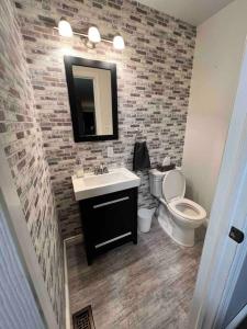 uma casa de banho com um lavatório, um WC e um espelho. em Spacious 4 Bedroom Forest Escape [Sunroom+Firepit] em Kawartha Lakes