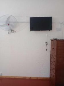pared con TV de pantalla plana y ventilador en Cabaña Adonay Mina Clavero en Mina Clavero