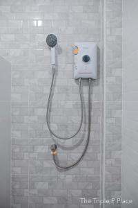 uma casa de banho com uma cabeça de chuveiro em The Triple P Place เดอะ​ทริปเปิลพีเพลส em Ban Non Sung