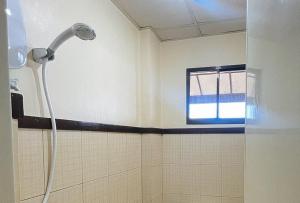 a shower in a bathroom with a window at RedDoorz @ Cion Suites Mintal Davao in Davao City