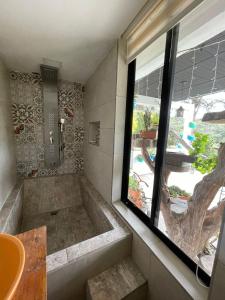 a bathroom with a large tub and a window at Hotel Campestre Zona 7 cerca del aeropuerto en rioengro in Rionegro