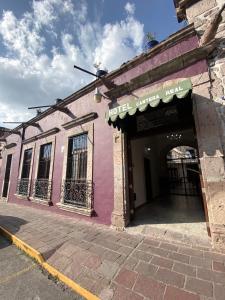 un edificio rosa con entrada a una tienda en Hotel Cantera Real, Morelia, en Morelia