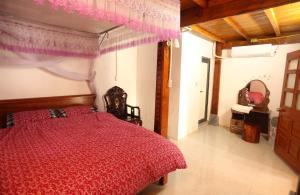 ein Schlafzimmer mit einem roten Bett mit einer roten Bettdecke in der Unterkunft Thái Sơn Homestay in Ha Giang