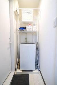 um pequeno frigorífico num quarto com uma porta em Direct to Namba,Korean town102 em Osaka