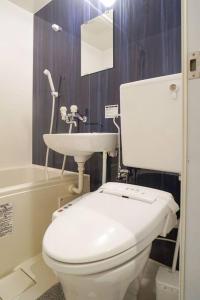 La salle de bains est pourvue de toilettes blanches et d'un lavabo. dans l'établissement Direct to Namba,Korean town102, à Osaka