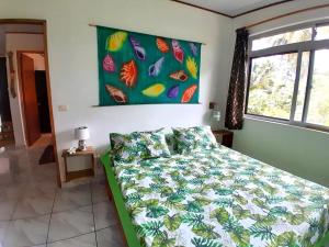 a bedroom with a bed with a colorful comforter at CHEZ VAIANA in Parea