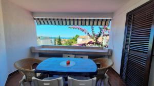a blue table and chairs in a room with a window at Mirjana Gajac in Gajac