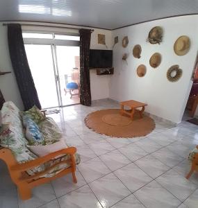 ein Wohnzimmer mit einem Sofa und einem TV in der Unterkunft CHEZ VAIANA in Parea