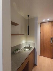 uma cozinha com um lavatório e uma porta de madeira em The Fields Hotel and Apartment em Seminyak