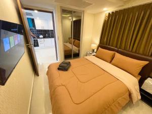 a bedroom with a bed with a black bag on it at Large 2 BR Condo, Grand Avenue, Central Pattaya in Pattaya