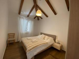 a bedroom with a bed and a chair in it at Holiday house with a parking space Lovran, Opatija - 9716 in Lovran