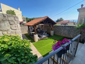 a garden with a gazebo and green grass at Holiday house with a parking space Lovran, Opatija - 9716 in Lovran