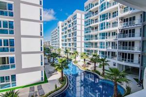 an aerial view of a building with a swimming pool and palm trees at Large 2 BR Condo, Grand Avenue, Central Pattaya in Pattaya