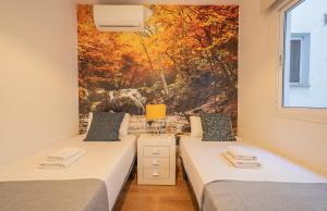 two beds in a room with a painting on the wall at Stay U-nique Apartment Ricardo Soriano in Marbella