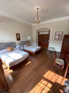 1 dormitorio con 2 camas, silla y lámpara de araña en Hotel Cantera Real, Morelia, en Morelia