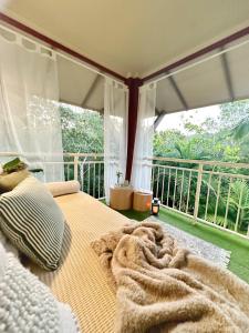 een slaapkamer met een bed en een groot raam bij Luxury 2 Bedroom apartment, Treetop views, Resort with 4 swimming pools in Cairns North