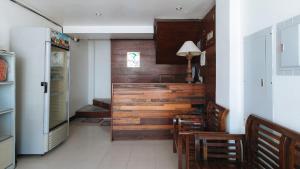 a kitchen with wooden walls and a refrigerator at WestCourt Inn Ilocos Sur in Bantaoay