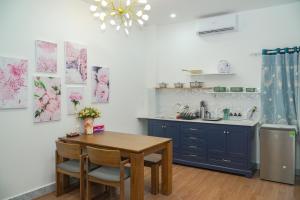 a kitchen with a table and blue cabinets and a sink at Palas House in Ho Chi Minh City