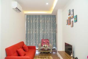 Palas House في مدينة هوشي منه: غرفة معيشة مع أريكة حمراء وكرسي