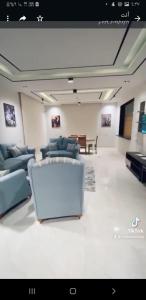 a living room with couches and a laptop on the floor at فيلاه مستقله ٤ غرف نوم ٤ حمامات لاندسكيب حمام سباحه خصوصيات كامله in El Alamein