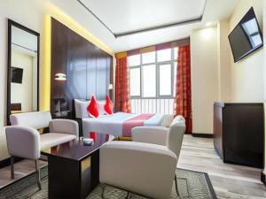 a hotel room with two beds and a tv at SHH Hotel in Fujairah