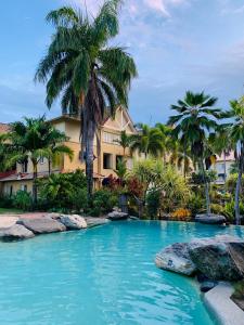 a pool in front of a resort with palm trees at Luxury tropical 2bedroom apartment in resort 4 swimming pools in Cairns North