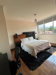 a bedroom with a bed and a large window at Estratégico, Elegante y equipado in Cochabamba