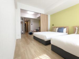 um quarto de hotel com duas camas e um corredor em ESLEAD HOTEL Namba South Ⅲ em Osaka